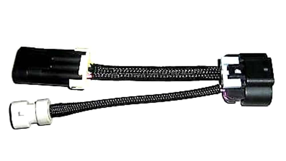 A black automotive wiring harness adapter with two connectors and insulated wires, one end with a larger black connector and the other with two smaller black and white connectors.